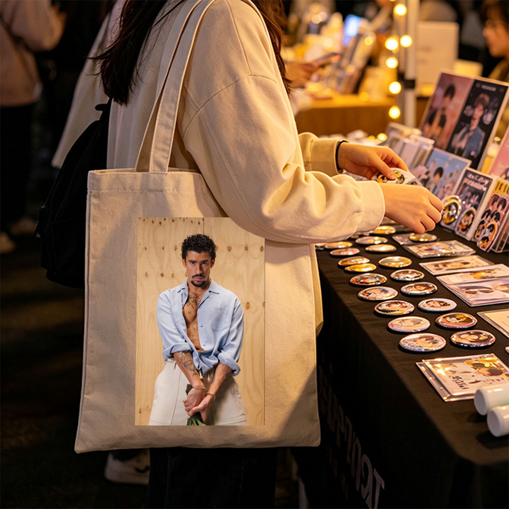 Bad Bunny in a Casual Pose Wearing an Open Light Blue Shirt and Beige Pants Against a Wooden Background - Canvas tote bags