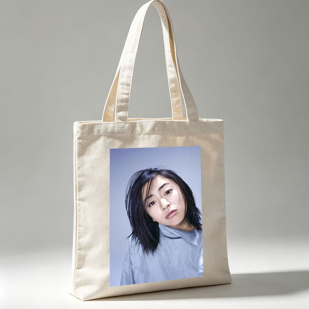 Yuki Kajiura in a Serene Portrait Wearing a Light Blue Collared Shirt Against a Soft Gray Background - Canvas tote bags