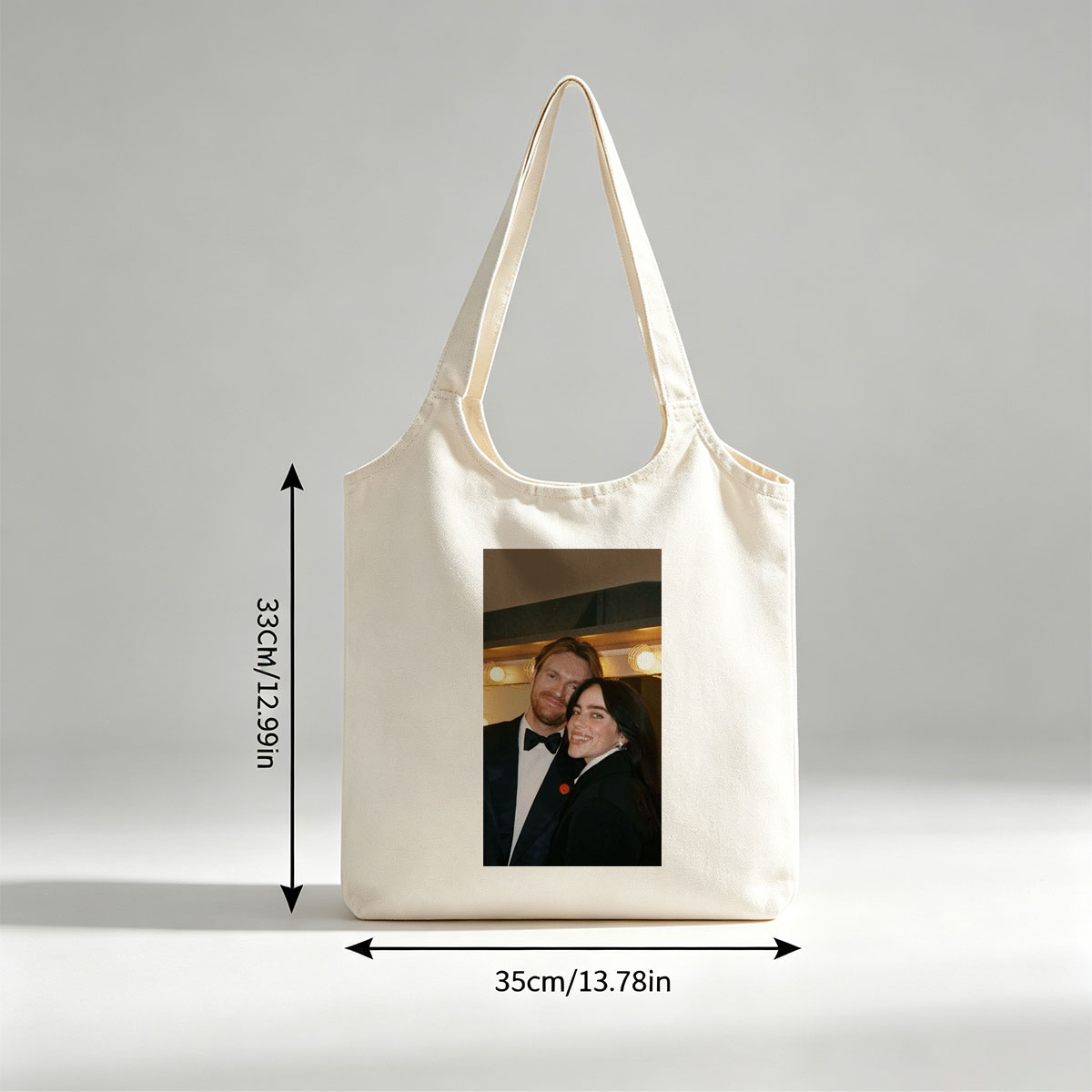 Lily Collins and Sam Claflin at a glamorous event, smiling together in formal attire with warm lighting in the background. - Canvas shoulder bags/