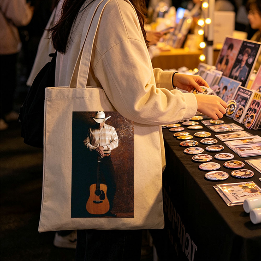 George Strait Holding Acoustic Guitar in Cowboy Attire Against Rustic Background - Canvas tote bags