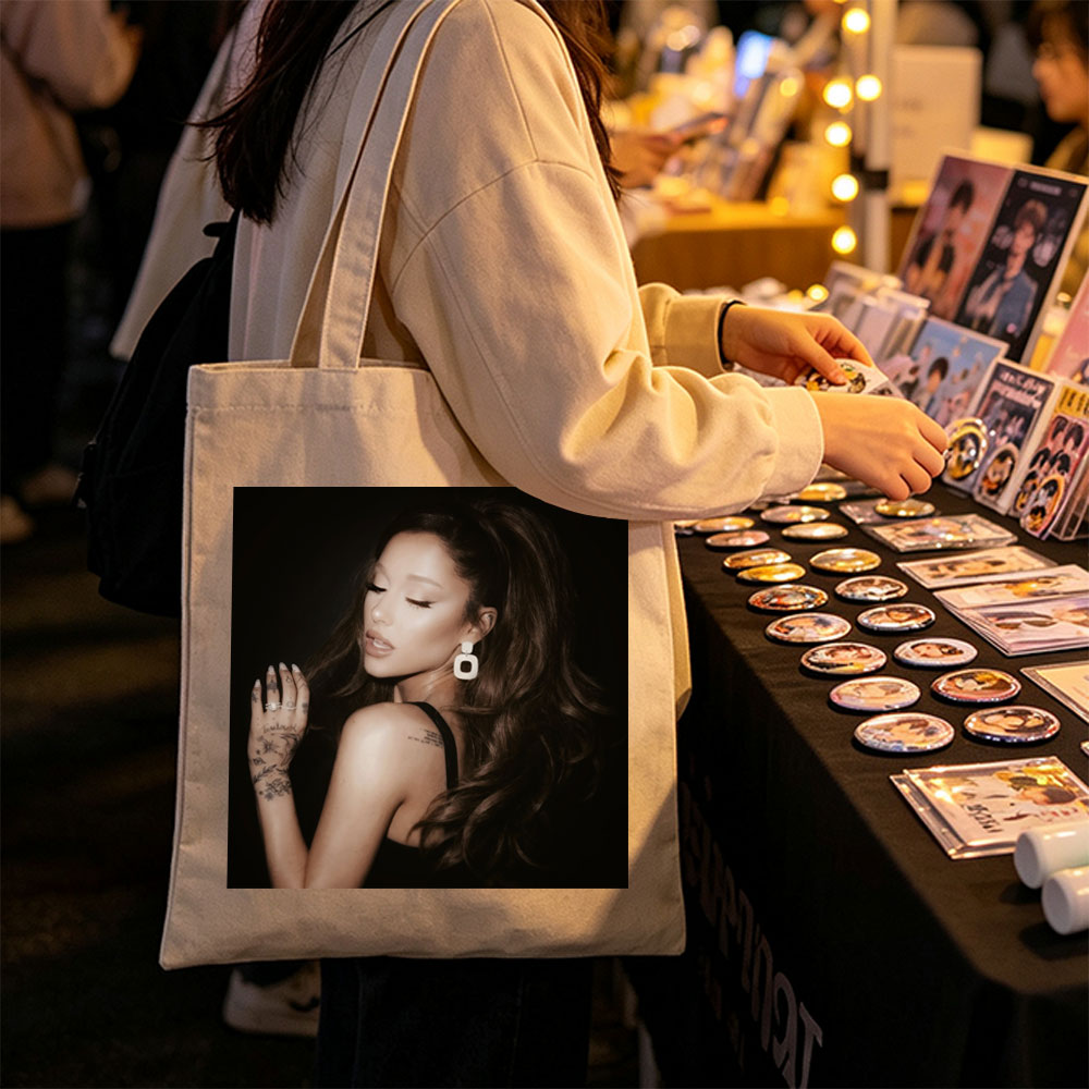 Ariana Grande in a Dramatic Pose with Long Hair and Tattoos on Dark Background - Canvas tote bags