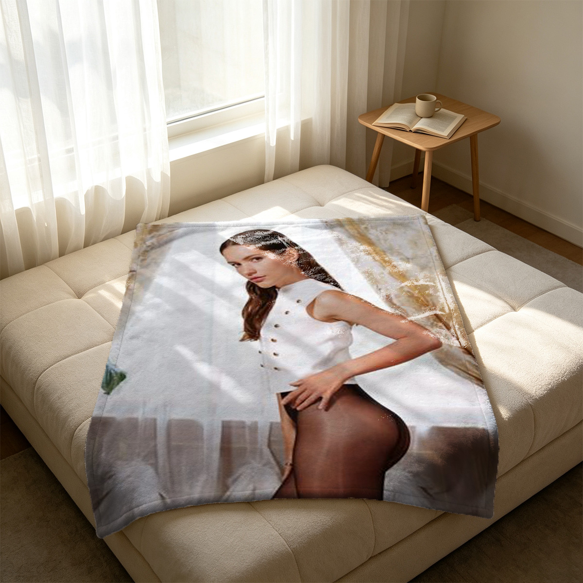 Emma Watson in white top lying on grey sofa reaching for ultrasound photo. - Blanket