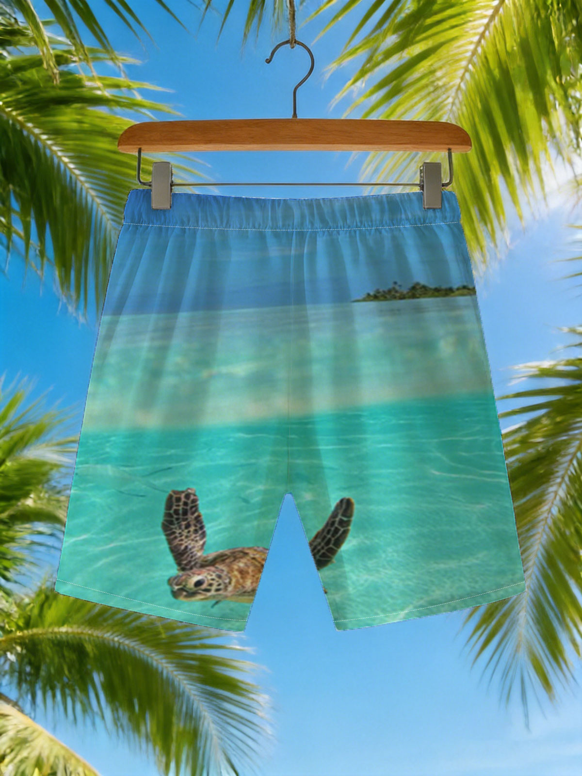 Sea turtle swims in crystal-clear turquoise waters near a tropical island. -  Beach shorts