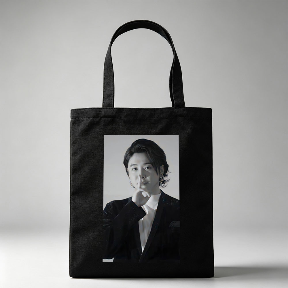 Kai from EXO in a dramatic pose with finger on lips, wearing a sparkling black suit and white shirt, set against a neutral background. - Canvas tote bags