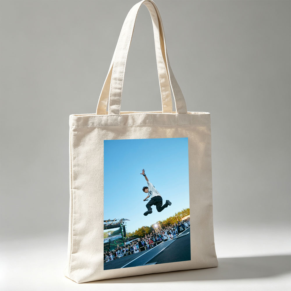 Skateboarder in Mid-Air Trick at Outdoor Festival with Crowd Watching - Canvas tote bags