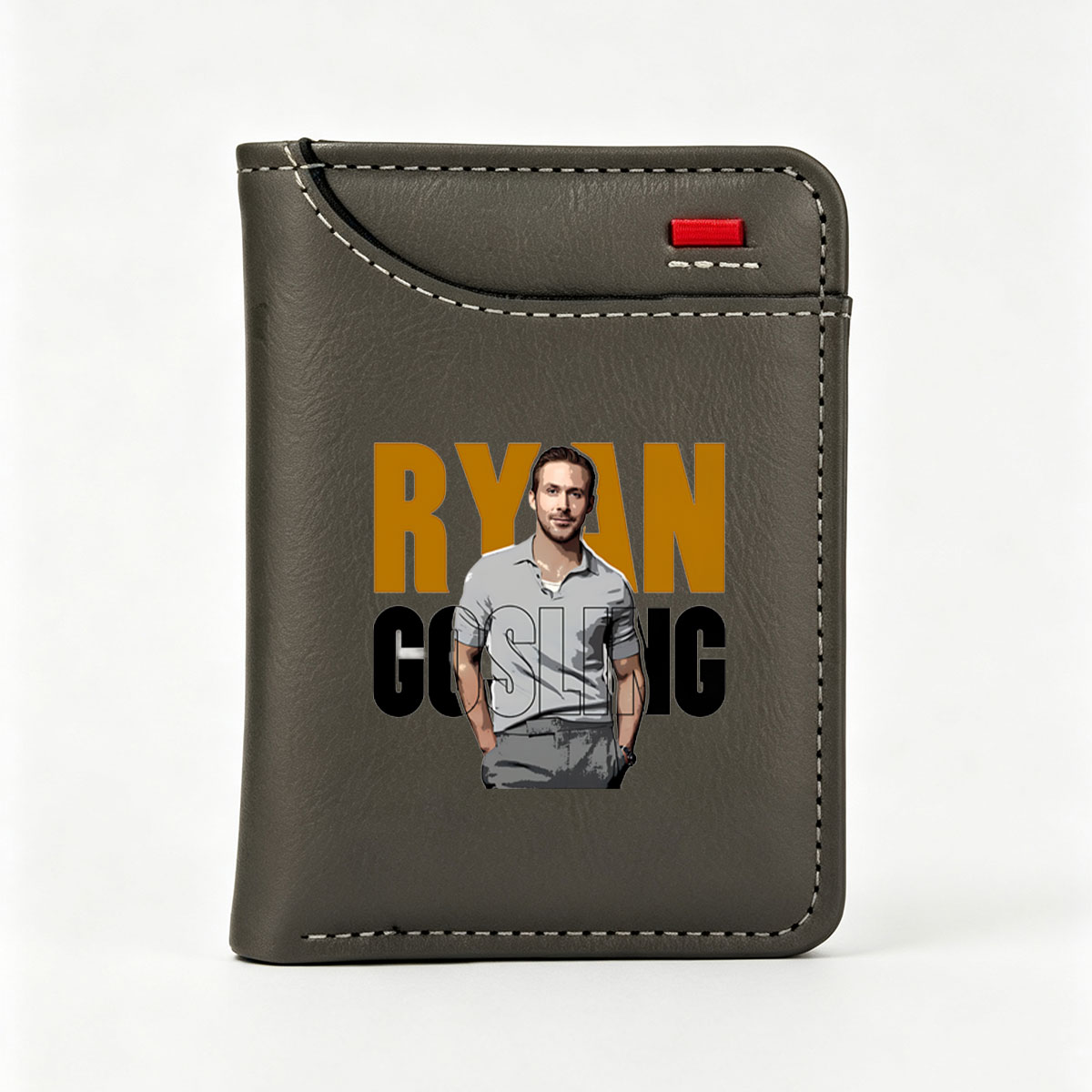 Ryan Gosling in a stylish gray polo shirt, standing confidently with hands in pockets, set against bold text backdrop. - Vertical Style Wallet