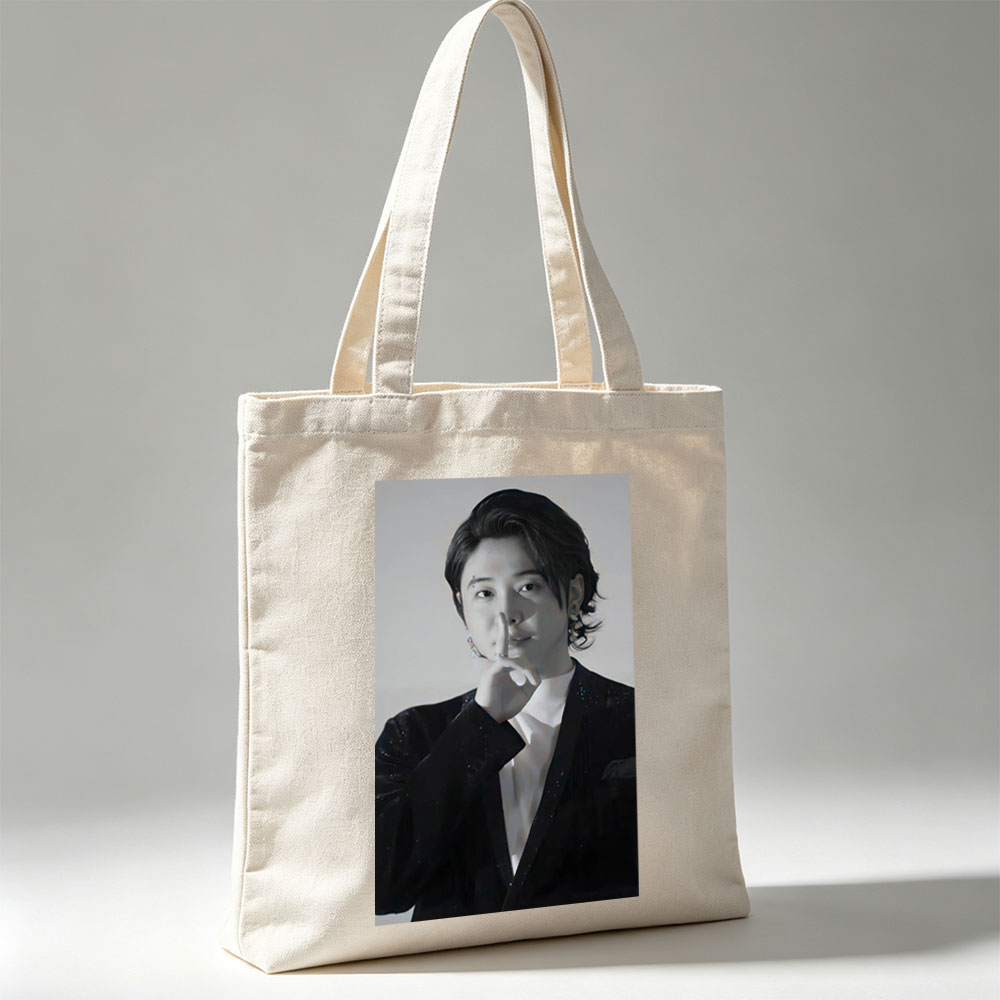 Kai from EXO in a dramatic pose with finger on lips, wearing a sparkling black suit and white shirt, set against a neutral background. - Canvas tote bags