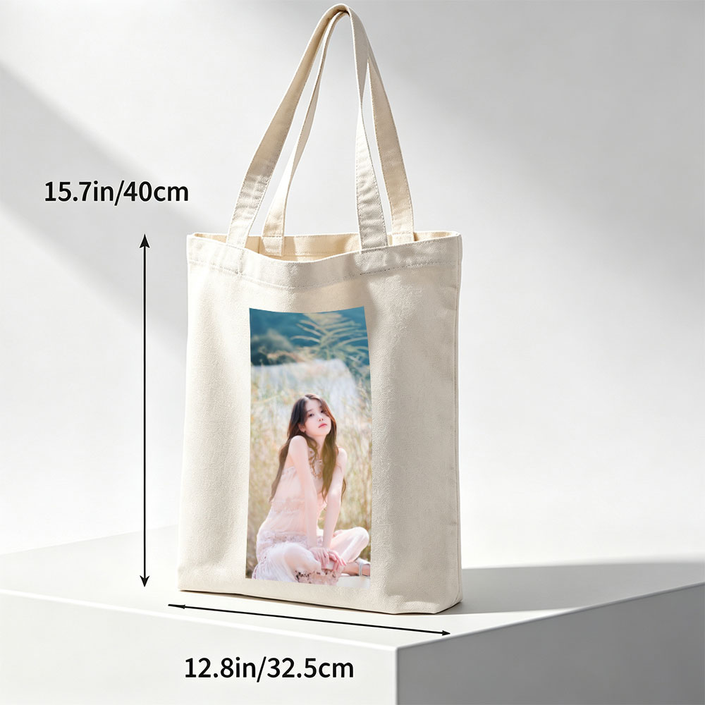 IU in a Serene Field Wearing a Delicate Pink Dress and Sitting Gracefully Amidst Tall Grass - Canvas tote bags