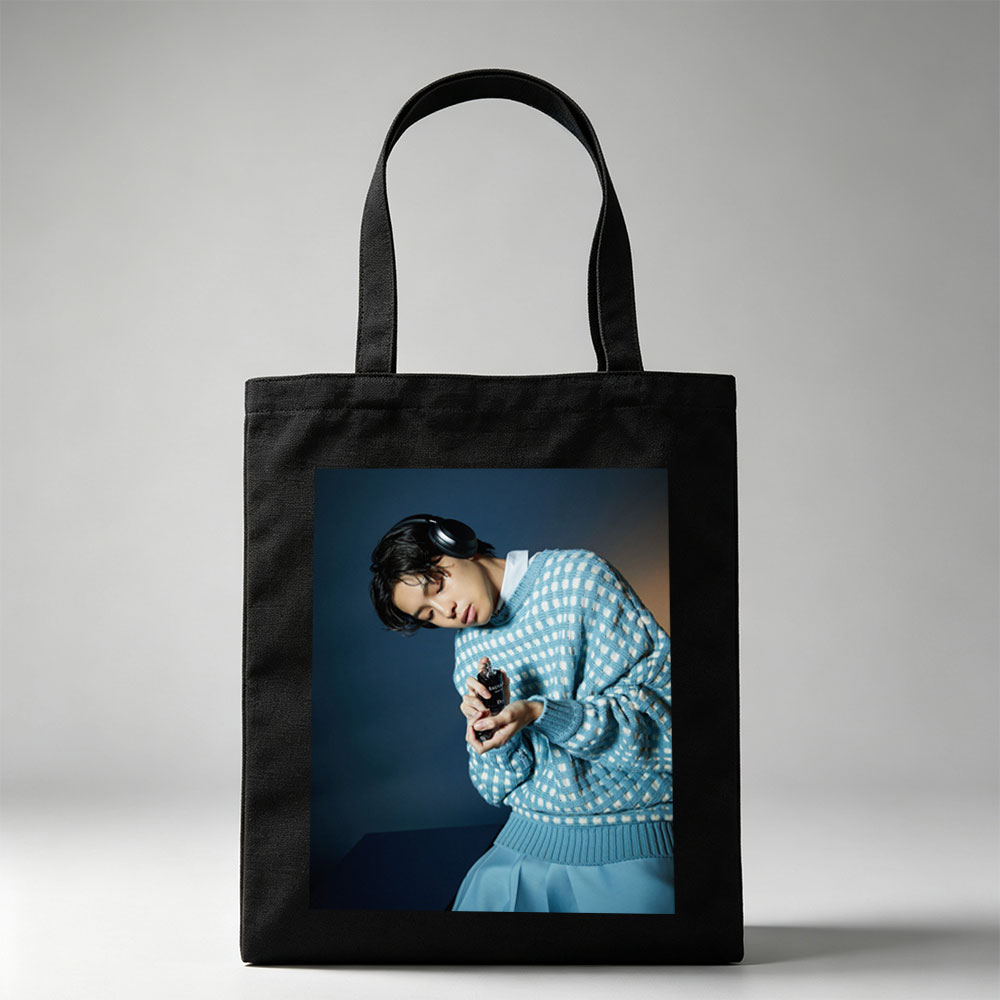 Jaden Smith in a Stylish Blue Sweater Holding a Perfume Bottle with Headphones On - Canvas tote bags