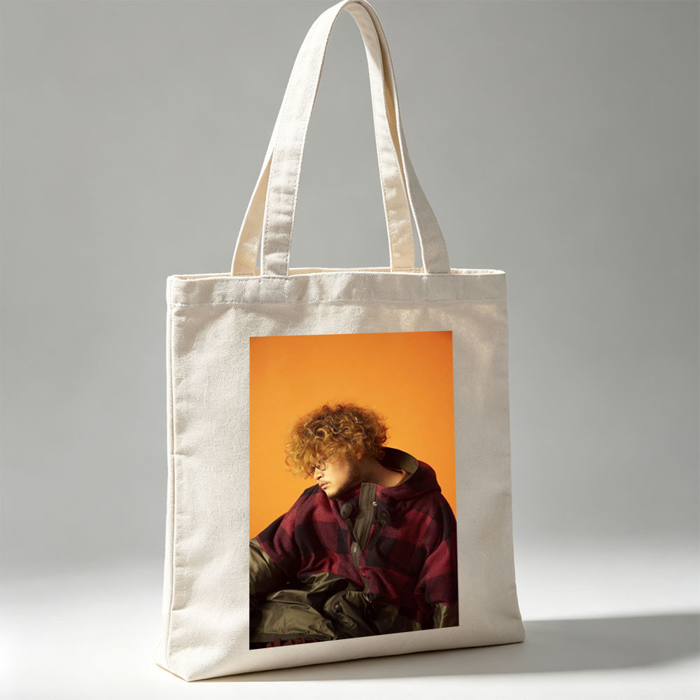 Takashi Miyagawa in a Moody Portrait Wearing a Plaid Hoodie Against an Orange Background - Canvas tote bags