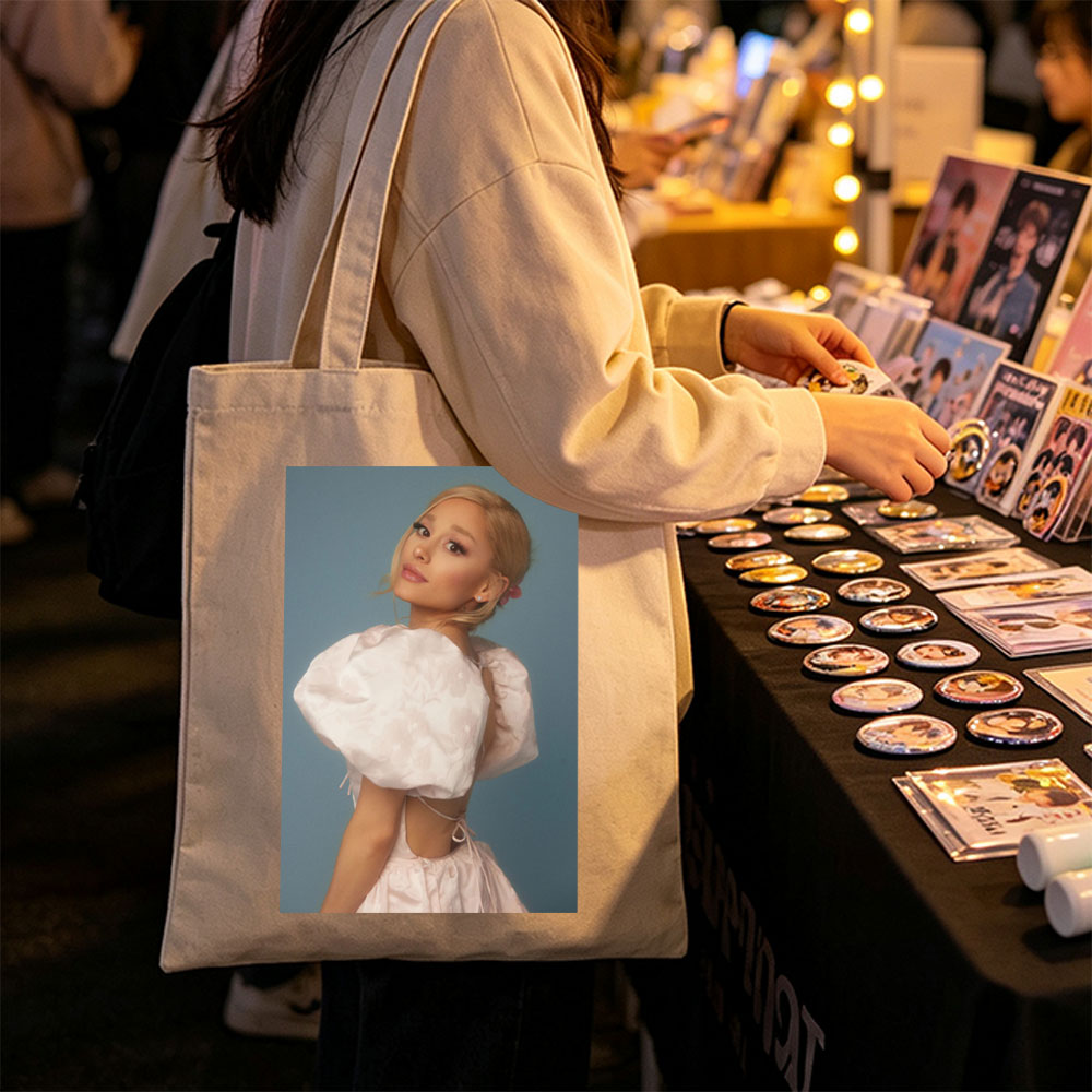 Ariana Grande in a Soft Pink Dress with Puffy Sleeves and Back Cutout Pose Against Blue Background - Canvas tote bags
