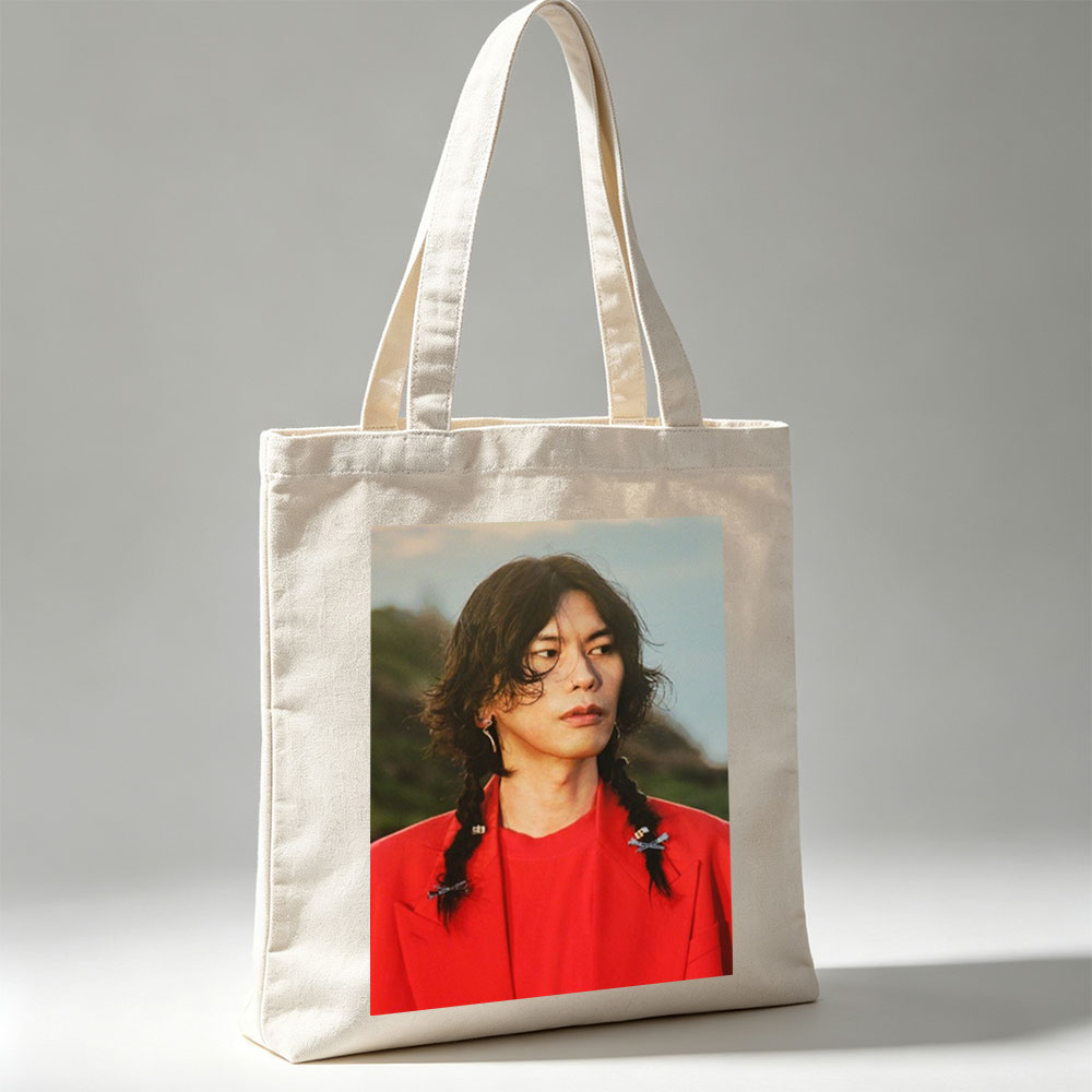 Miyavi in a Bold Red Outfit with Braided Hair and Crossed Pins, Standing Against a Natural Backdrop - Canvas tote bags