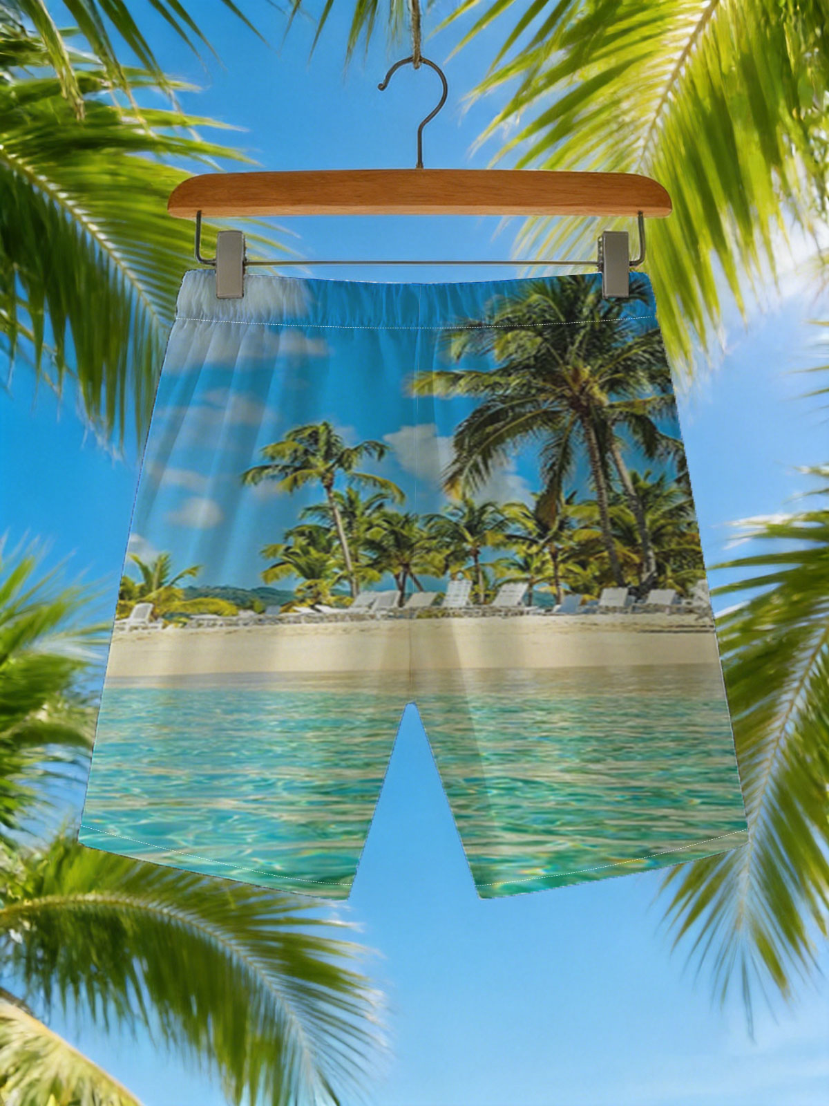 Crystal clear waters meet sandy beach with palm trees and lounge chairs under a bright blue sky. -  Beach shorts