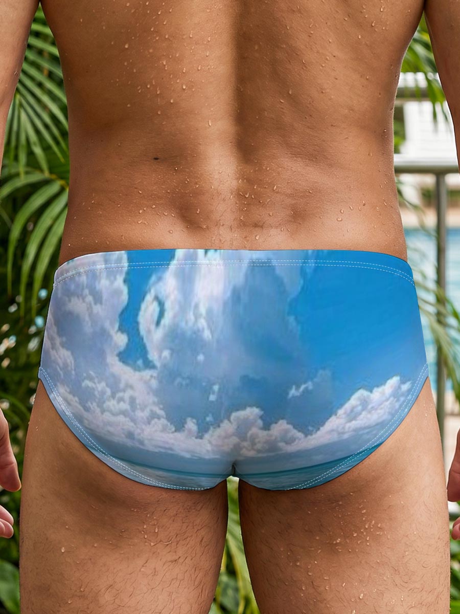 Crystal clear turquoise waters meet soft sandy beach under a vibrant blue sky with fluffy white clouds. -  Men's swim trunks
