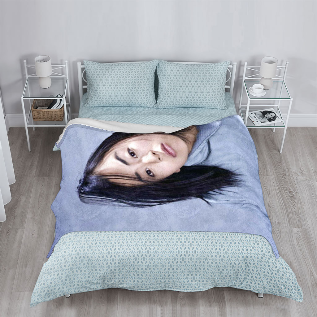 Yuki Kajiura in a Serene Portrait Wearing a Light Blue Collared Shirt Against a Soft Gray Background - Blankets