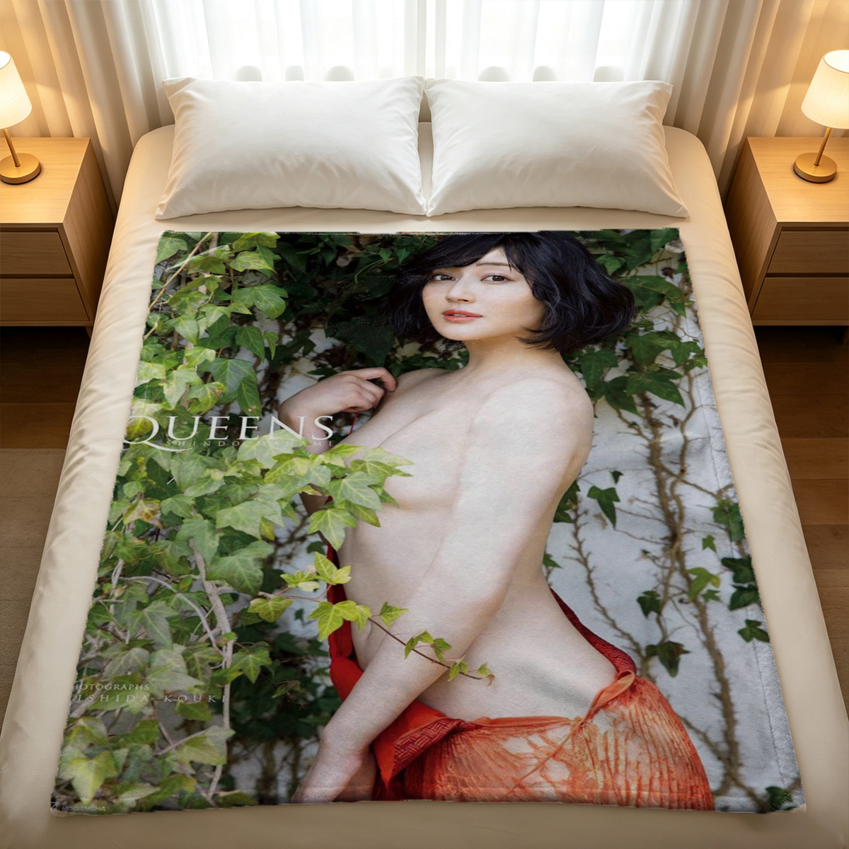 A woman in an unbuttoned white shirt kneeling on a bed, looking back over her shoulder. - Blanket