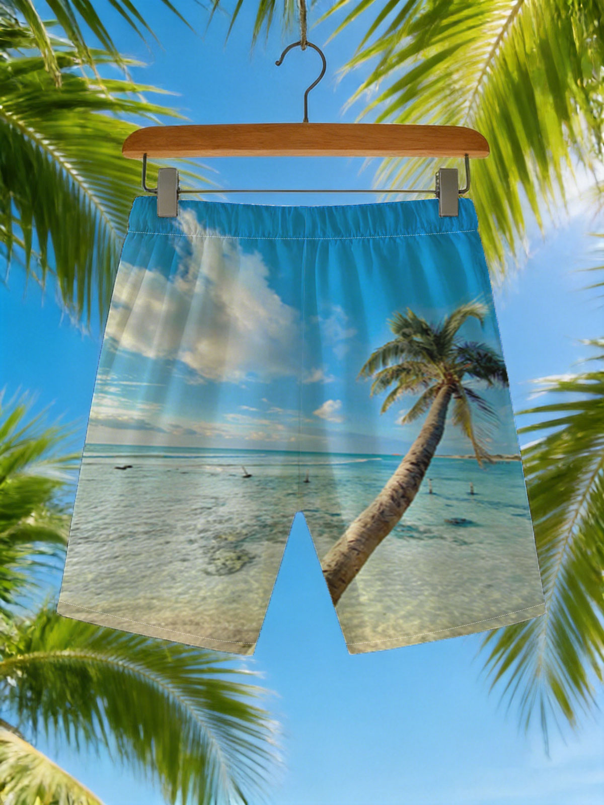 Tropical beach with palm tree leaning over clear blue water under a bright sky. -  Beach shorts