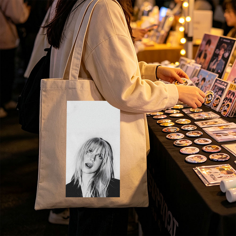 Bebe Rexha in a striking black and white portrait with tousled blonde hair and bold expression - Canvas tote bags
