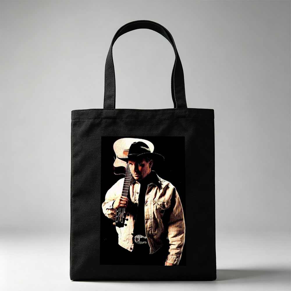 Garth Brook Holding Acoustic Guitar in Cowboy Attire Against Dark Background - Canvas tote bags