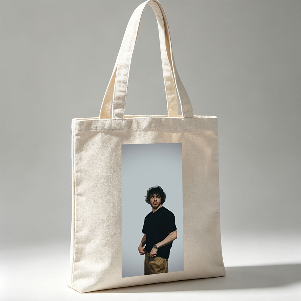 Jack Whitehall in a Casual Pose Wearing a Black T-Shirt and Beige Pants Against a Neutral Background - Canvas tote bags