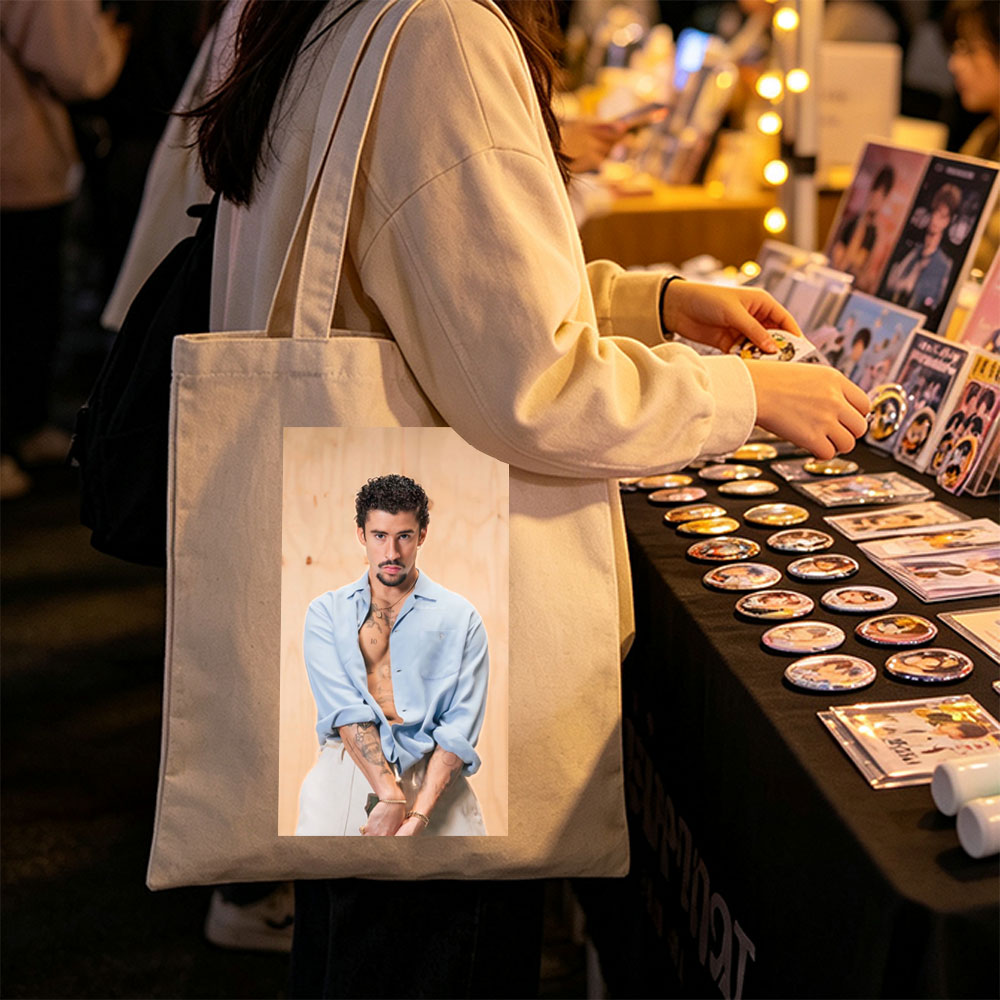 Bad Bunny in a Casual Pose Wearing an Open Light Blue Shirt and White Pants with Visible Tattoos - Canvas tote bags