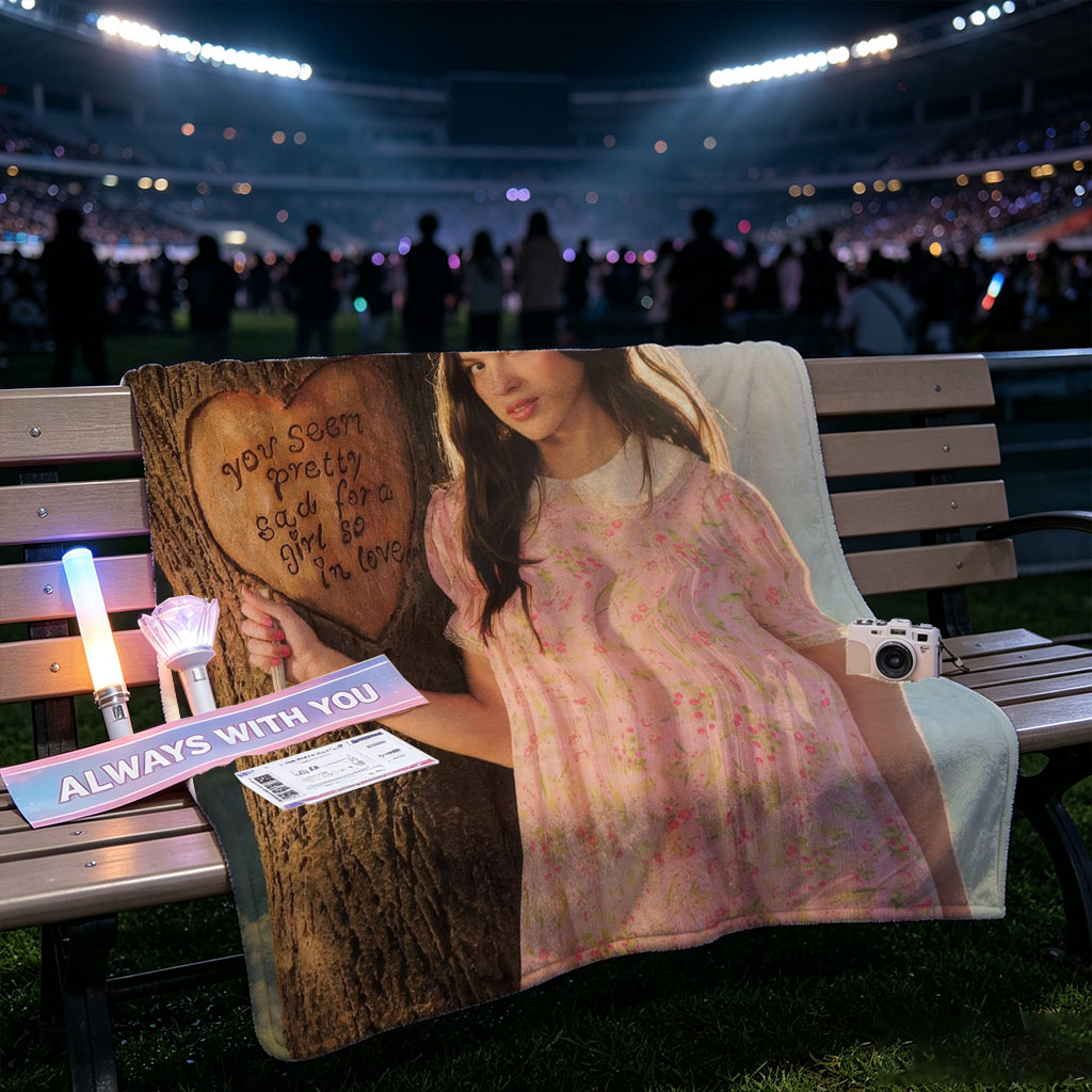 Olivia Rodrigo in a Romantic Outdoor Scene Wearing a Pink Floral Dress Leaning Against a Tree with a Heart Carved Message - Blankets