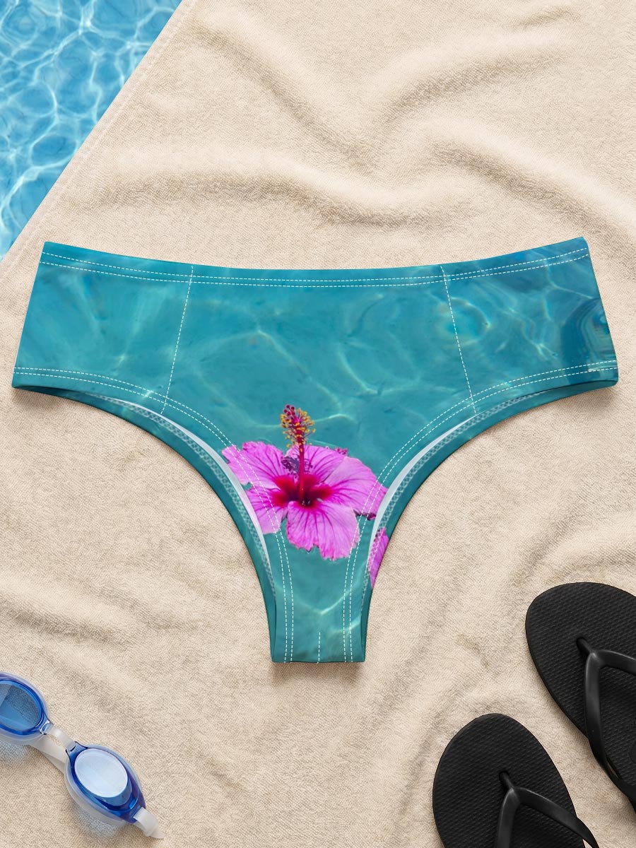 Pink hibiscus floating on crystal clear turquoise water -  Men's swim trunks