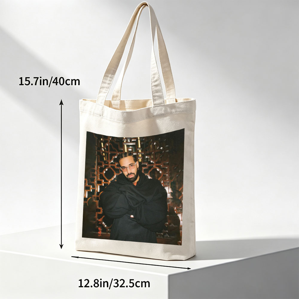 Drake in a Stylish Pose Against an Ornate Background Wearing Glasses and a Black Hoodie - Canvas tote bags