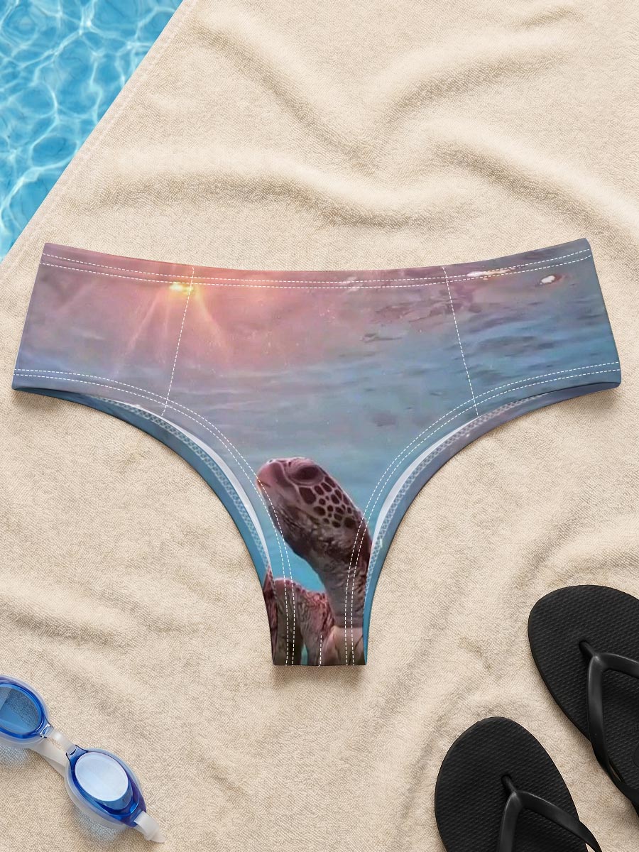 Sea turtle swims gracefully underwater as sunlight filters through the ocean surface. -  Men's swim trunks