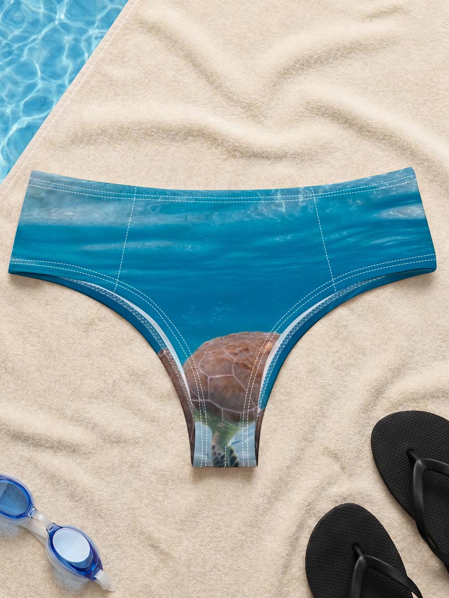 Sea turtle swims gracefully in clear blue water with fish below, sunlight filtering through the surface. -  Men's swim trunks