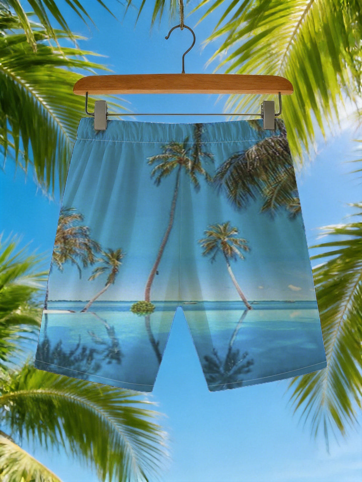 Tropical palm trees reflected in crystal-clear infinity pool under a vibrant blue sky. -  Beach shorts