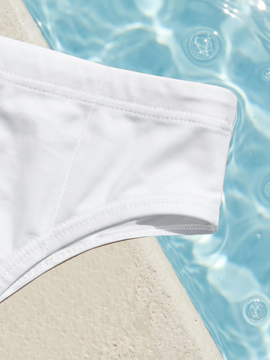 A vibrant orange fish swims gracefully in clear blue waters beneath a sunny sky. -  Men's swim trunks geometric print swim briefs on tropical beach