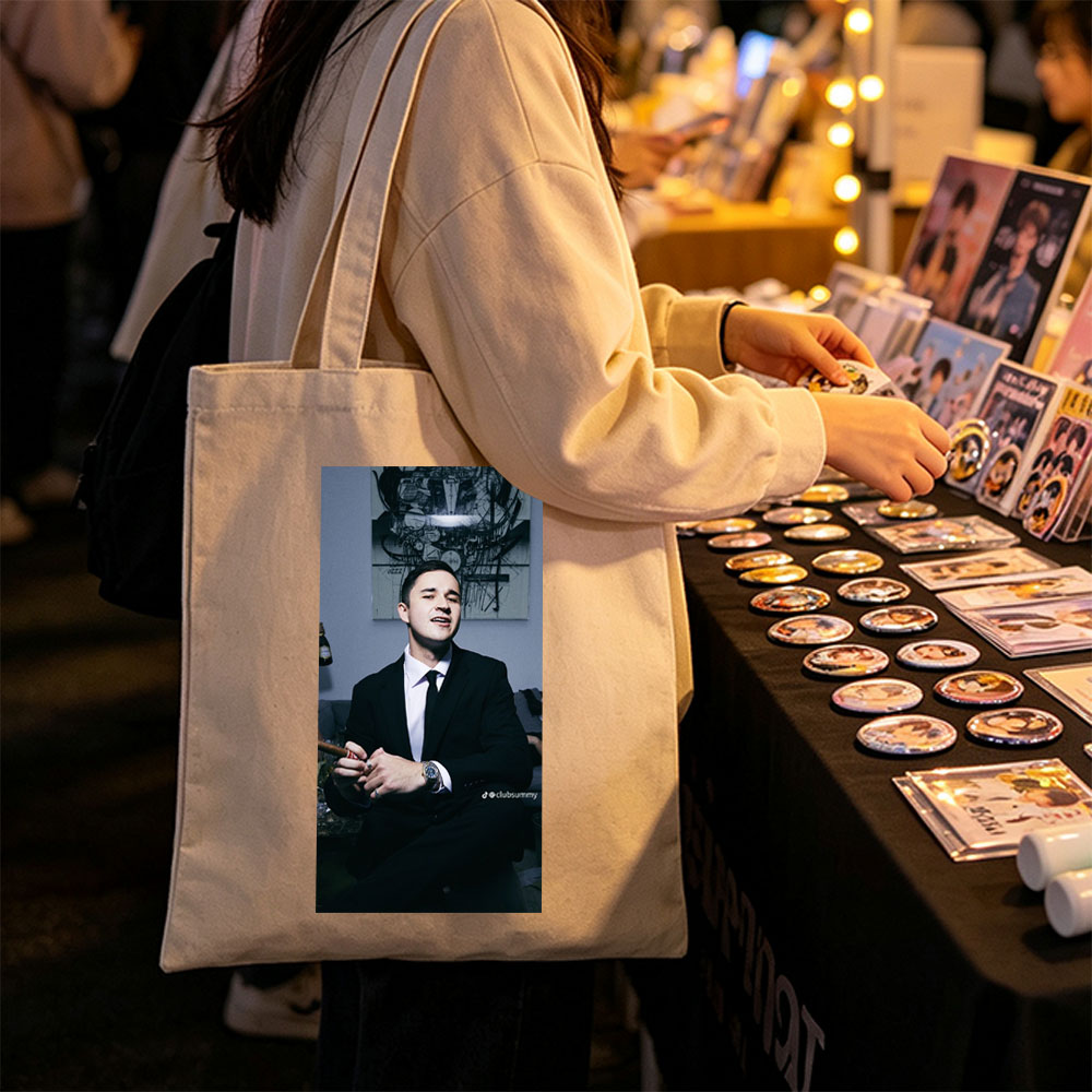 Pete Davidson in a Suit Holding a Cigar with Artwork in the Background - Canvas tote bags