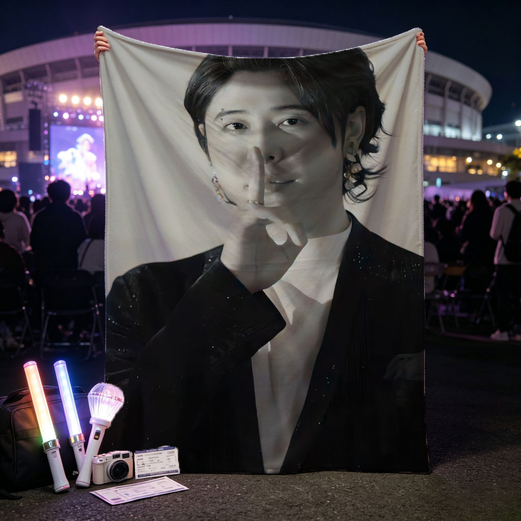 Kai from EXO in a dramatic pose with finger on lips, wearing a sparkling black suit and white shirt, set against a neutral background. - Blankets