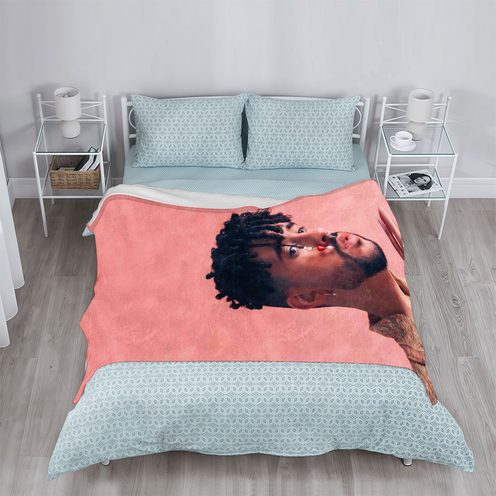 Bad Bunny in a Stylish Pose Against a Pink Background Wearing a Patterned Shirt and Red Nose Jewelry - Blankets