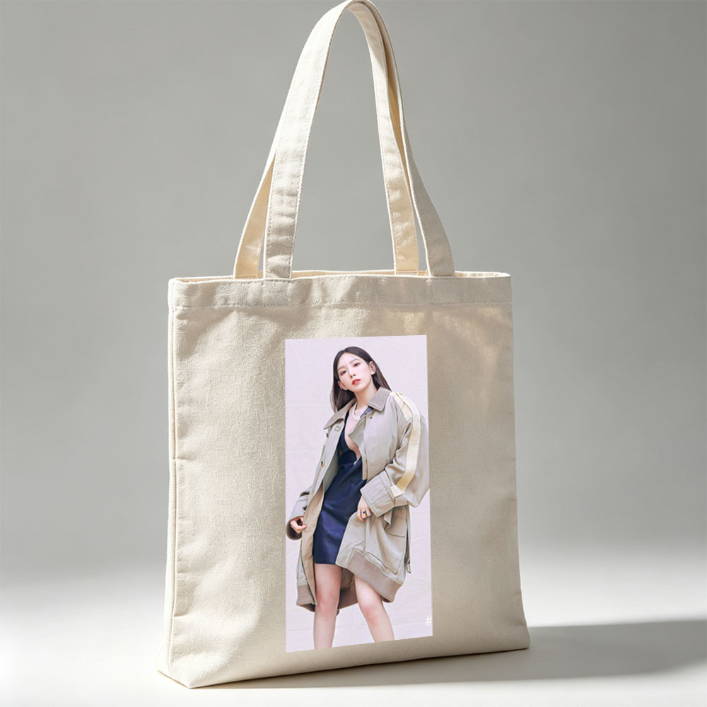 Kim Go Eun in a stylish urban look wearing a beige oversized coat over a navy blue dress, posing confidently against a neutral backdrop. - Canvas tote bags