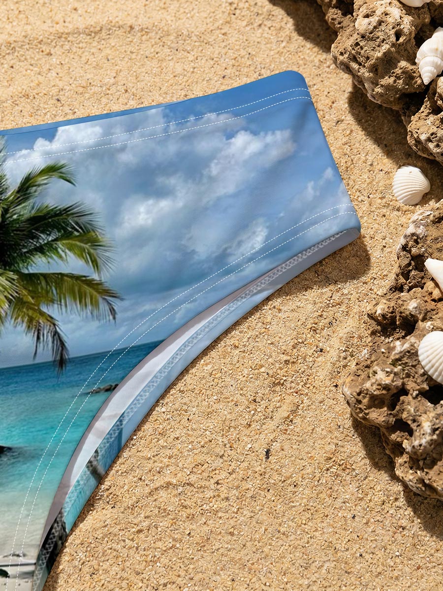 Tropical beach with palm tree leaning over turquoise water and white sand under blue sky. -  Men's swim trunks
