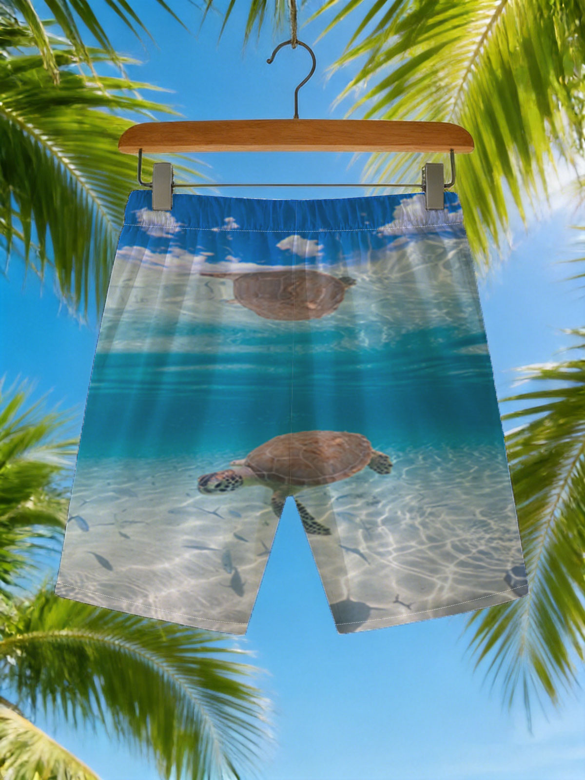 Sea turtle swims gracefully in clear blue water with fish below, sunlight filtering through the surface. -  Beach shorts