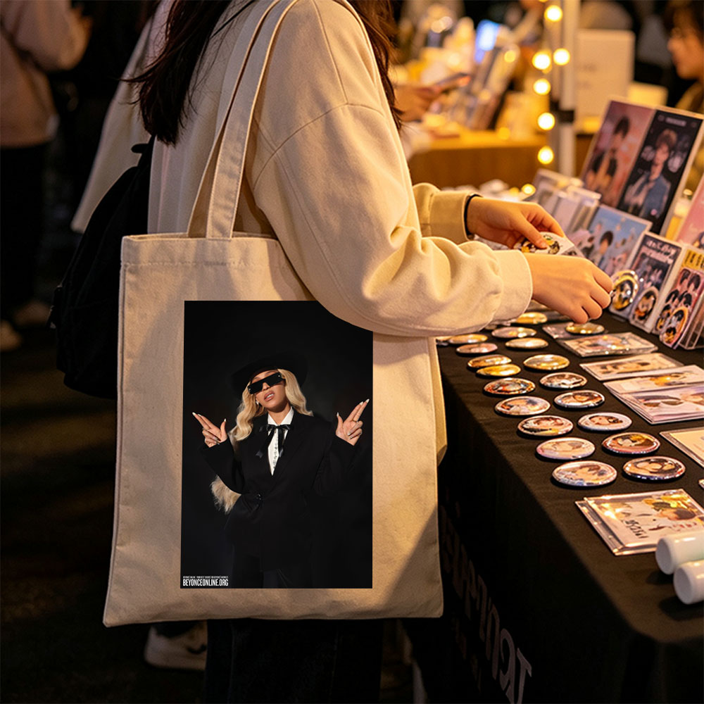 Beyonce in a Bold Black Suit and Hat Making Peace Signs Against a Dark Background - Canvas tote bags