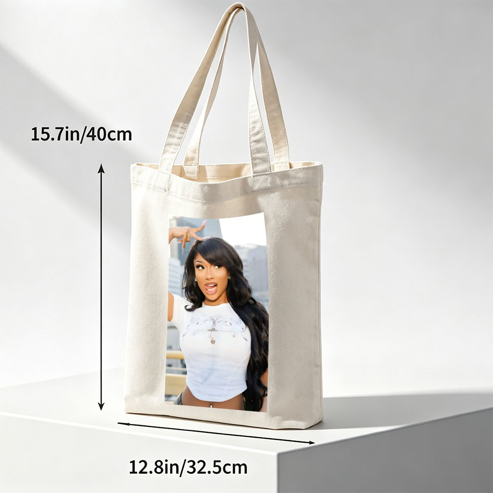 Megan Thee Stallion in a Bold Pose Wearing a White Crop Top with Cross Design and Long Black Hair Against a City Skyline Background - Canvas tote bags