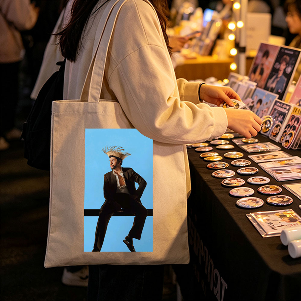 Bad Bunny in a Bold Fashion Statement Wearing a Straw Hat and Suit Against a Blue Background - Canvas tote bags