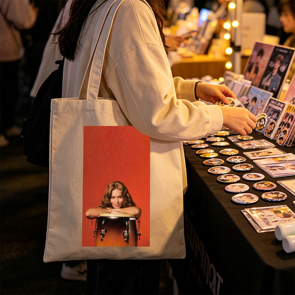 Rita Ora Leaning on a Drum Against a Red Background - Canvas tote bags