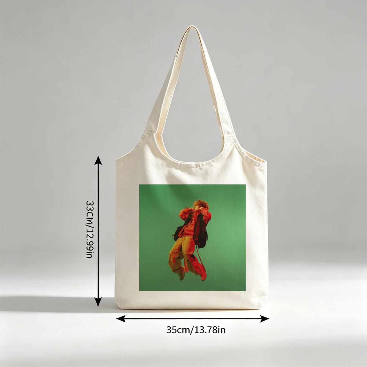 Troye Sivan in a vibrant red and yellow outfit mid-jump against a green background - Canvas shoulder bags/