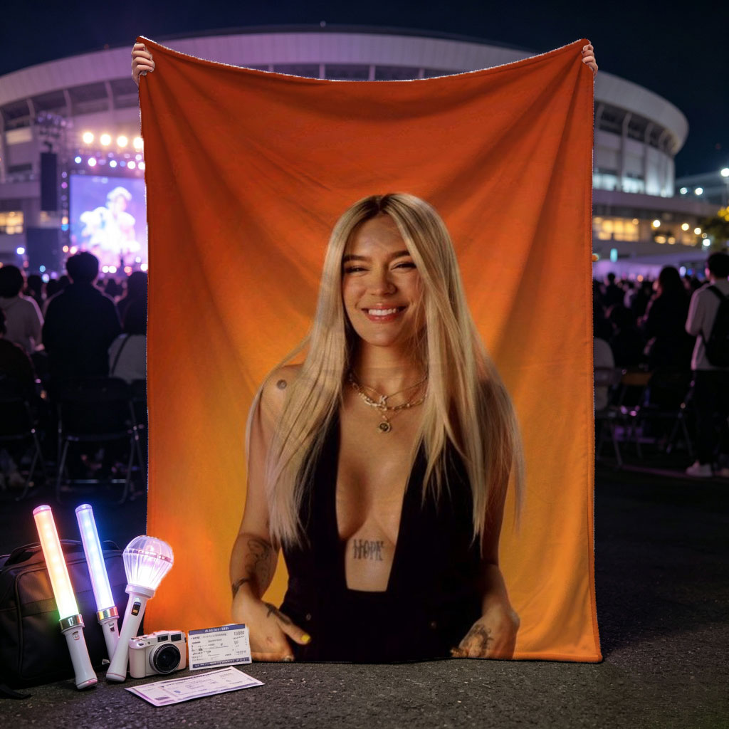 Bebe Rexha in a Bold Black Outfit Against a Vibrant Orange Background, Smiling with Confidence - Blankets