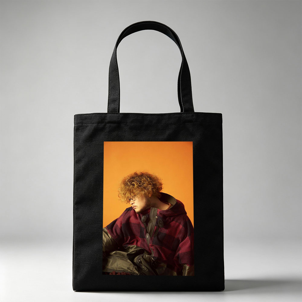 Takashi Miyagawa in a Moody Portrait Wearing a Plaid Hoodie Against an Orange Background - Canvas tote bags