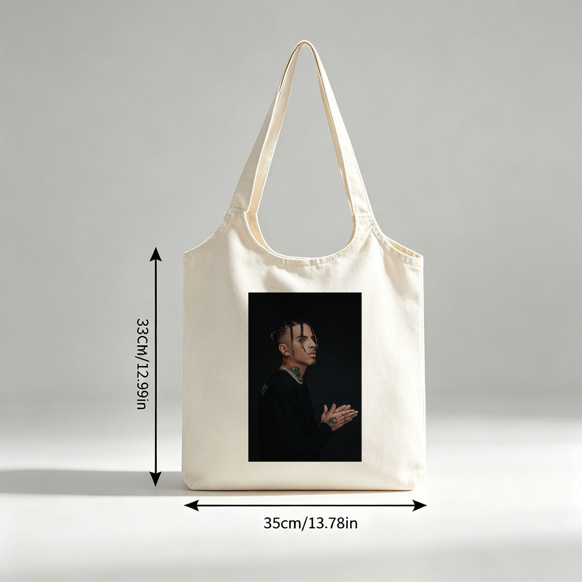 Daddy Yankee in a striking pose with braided hair and tattoos, wearing a black outfit and gold chain against a dark background. - Canvas shoulder bags/