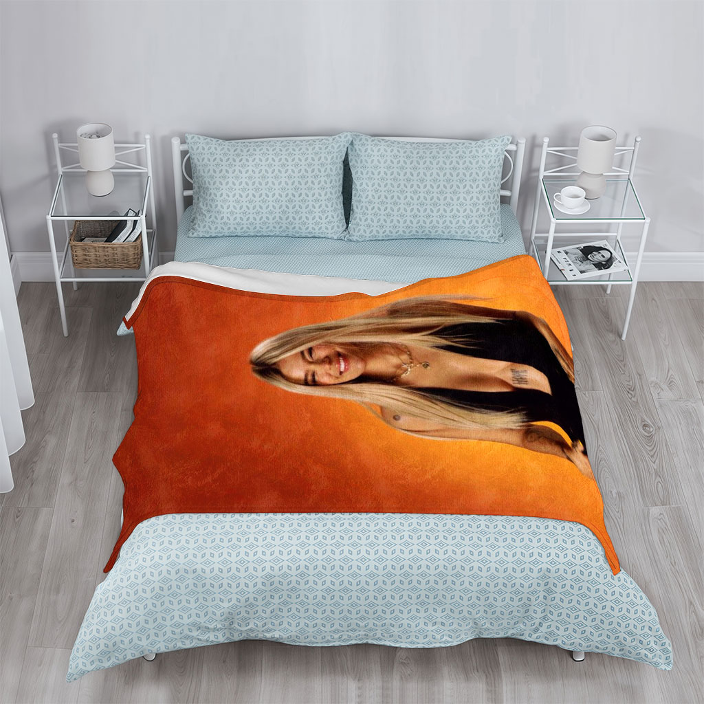 Bebe Rexha in a Bold Black Outfit Against a Vibrant Orange Background, Smiling with Confidence - Blankets