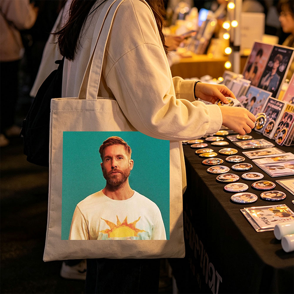 Calvin Harris in a Sun-Themed T-Shirt Against a Teal Background - Canvas tote bags