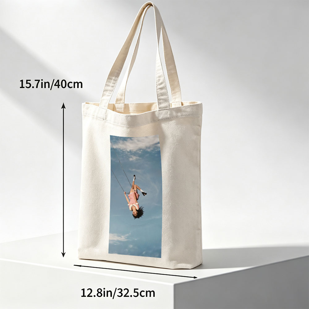 Taylor Swift Swinging on a Chain Against a Blue Sky - Canvas tote bags