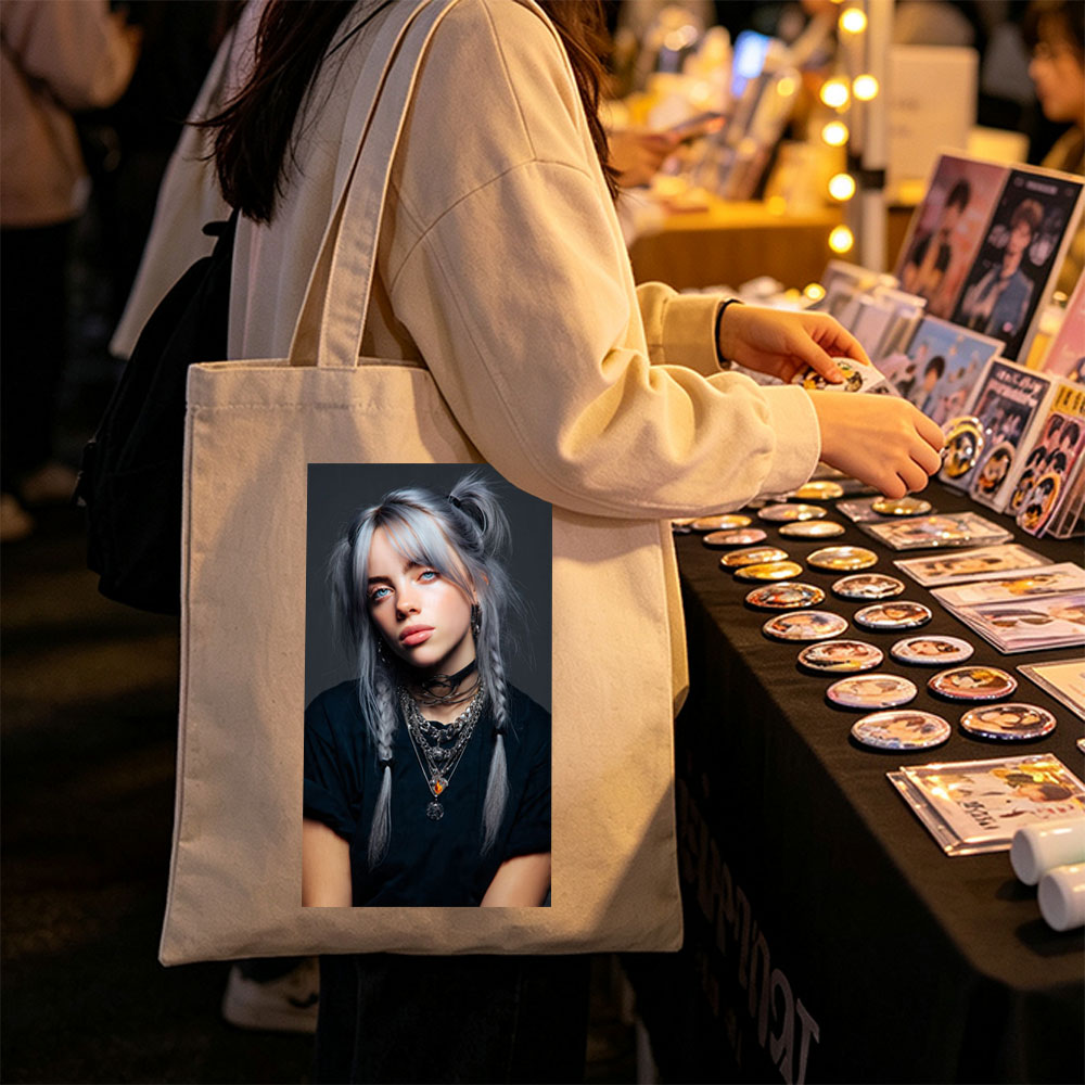 Billie Eilish in a striking portrait with silver hair styled in braids, wearing layered necklaces and a black top against a dark background. - Canvas tote bags
